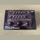 Černý kytarový pedál s nápisy BOSS a Acoustic Preamp AD-10. Zařízení má na horním panelu řadu ovládacích knoflíků, přepínačů a malý digitální displej…