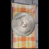 Kruhový činel z kovu s viditelnou strukturou broušení povrchu. Na povrchu jsou černé nápisy „Istanbul Agop Made in Turkey“ a „XIST 20" / 60 cm Ride“.…