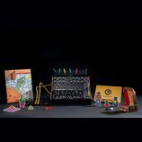 Černý analogový syntetizátor s nápisy moog a MOTHER-32 v dolní části. Přístroj je osazen několika ovládacími knoflíky, přepínači a zapojenými patch k…