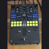 Černý DJ mixér značky Pioneer DJ, model PERFORMANCE MIXER DJM-S9. Zařízení obsahuje zahlreichetočítka, posuvníky a dvě řady podsvícených žlutých perf…