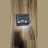 Černý efekt pedál s nápisy MXR, BASS INNOVATIONS a bass d.i.+. Na horní straně jsou čtyři otočné ovladače s popisky DISTORTION, GATE, COLOR a nečitel…