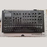 Stříbrný syntetizátor s nápisy Roland SYNTHESIZER SH-4d. Přístroj obsahuje zahlreiche ovládací knoflíky, čtyři vertikální posuvníky a několik řad mal…