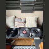 Tři vinylové desky v obalech položené na bílém podkladu. Na dvou z nich je viditelný nápis TRAX a SCRATCH, přičemž prostřední disk má červený středov…