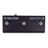 Černý nožní spínač s třemi kovovými tlačítky. Na horní straně je bílý nápis TC HELICON a SWITCH-3. Tlačítka jsou vlevo doprava označena číslicemi 1,…