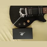 Černá elektrická kytara s chromovaným hardwarem a dvěma snímači. Na jednom ze snímačů je nápis Signature Humbucker. Pod snímači se nachází přepínač s…