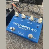 Modrý kytarový efekt s nápisy VOLUME, TONE, OVERDRIVE a BOOST. Na horní straně je velký bílý nápis FULL-DRIVE 2 MOSFET a pod ním text Handmade in the…