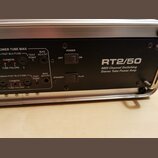 Detail zadní strany černého zesilovače s nápisem RT2/50 a popiskem MIDI Channel Switching Stereo Tube Power Amp. Jsou zde vidět dva přepínače s označ…