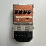 Stompbox efekt s nápisem TAP TREMOLO a logem LINE 6 na spodním pedálu. Horní panel je v hnědé barvě se čtyřmi ovládacími knoflíky popsanými jako SPEE…