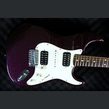 Elektrická kytara s tmavě fialovým metalizovaným povrchem těla a bílým pickguardem. Nástroj má konfiguraci snímačů humbucker-single-humbucker a tři b…
