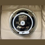 Kruhový reproduktor s kovovým rámem v béžovém odstínu. Na černém středovém krytu je zlatý nápis CELESTION LOUDSPEAKERS, pod ním označení G12 G12 a mo…