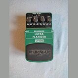 Zelený efekt pedál s nápisy BEHRINGER, ULTRA FLANGER a UF100. V horní části jsou čtyři ovládací knoflíky s popisky MANUAL, DEPTH, RATE a RES, doplněn…