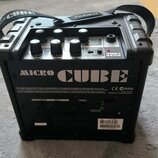 Černý kombozesilovač s rukojetí a popruhem, na kterém je nápis Roland. Na zadním panelu je velký bílý nápis MICRO CUBE, logo CE a označení N225. Jsou…