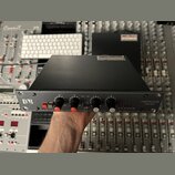 Černý rackový kompresor a limiter s kovovým předním panelem. Vlevo je logo DBR, vpravo nápis COMPRESSOR LIMITER dB. Přístroj má čtyři černé otočné kn…