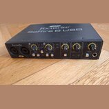 Černý zvukový interface s nápisem Focusrite Saffire 6 USB na horní straně a logem Focusrite vlevo na předním panelu. Přední strana obsahuje dva kombi…