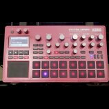 Červený sampler KORG electribe sampler MUSIC PRODUCTION STATION. Zařízení obsahuje displej, několik otočných knoflíků a mřížku podsvícených tlačítek.…