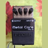Kytarový efekt pedál značky BOSS, model Metal Core ML-2. Zařízení má černé kovové tělo s bílým nápisem a čtyři ovládací knoflíky na stříbrném horním…