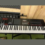 Černý MIDI kontrolér s klaviaturní klávesnicí. Na levé straně je červené logo AKAI PROFESSIONAL a bílý nápis MPK261. Horní panel obsahuje mřížku padů…