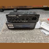 Černý patchbay s nápisem ROCKBOARD by WARWICK MOD 2 All-in-One TRS/MIDI/USB Patchbay. Zařízení obsahuje čtyři jack konektory označené písmeny A, B, C…