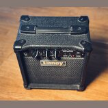 Černý basový kombo zesilovač s texturovaným povrchem a plastovými rohy. Na předním panelu je nápis BASS AMPLIFIER a model LX10B, v dolní části se nac…