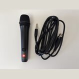 Černý dynamický mikrofon s mřížkou a připojeným černým kabelem. Na spodní části mikrofonu je umístěno červeno-bílé logo JBL a nad ním se nachází tlač…