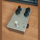 Stříbrný efekt pedál s dvěma černými oválnými knoflíky. Na spodní části je nápis HYPER LUMINAL a pod ním menším písmem HYBRID COMPRESSOR. Na horní čá…
