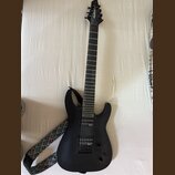 Černá elektrická kytara s matným povrchem a šesti strunami. Na hlavě hmatníku je bílý nápis Jackson. Nástroj má dva humbuckery, jeden ovládací knoflí…