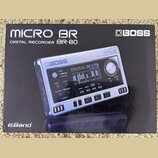 Fotografie zobrazuje černé originální balení digitálního nahrávače. Na krabici je bílý nápis MICRO BR DIGITAL RECORDER BR-80 a logo BOSS. V dolní čás…