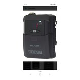 Černý bezdrátový vysílač s plastovým povrchem. Na zařízení jsou nápisy POWER/BATTERY, CH a model WL-60T spolu s logem BOSS. V horní části svítí zelen…