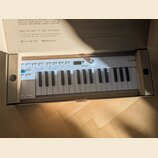 Bílá klávesová kontrola v originální krabici. Na přístroji je vidět logo ARTURIA a v pravém horním rohu nápis KEYSTEP. Klávesnice je v čistém stavu b…