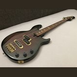 Elektrická basová kytara s tmavým, přechodovým lakem od červené po černou. Na hmatníku jsou vidět čtyři vložky s nápisem "YAMAHA". Nástroj má zlatý h…