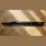 Černý elektronický dechový nástroj s nápisy EWIS5000 WIRELESS ELECTRONIC WIND INSTRUMENT a AKAI PROFESSIONAL. Nástroj leží na dřevěné podlaze. Povrch…