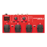 Červený kytarový efektový procesor s nápisem ZOOM GFX-1 GUITAR EFFECTS PROCESSOR. Zařízení má čtyři černé nožní spínače označené čísly 1 až 4 a digit…
