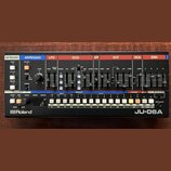 Černý syntetizátor s ovládacími prvky v horní části rozdělenými do barevných sekcí: KEYBOARD, ARPEGGIO, LFO, DCO, HPF, VCF, VCA a ENV. Na přední stra…