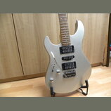 Stříbrná elektrická kytara s dvojstupňovými humbuckery a vibrační pákou. Kytara má dřevěný hmatník a dvě ovládací knoflíky v unteren části těla. Na n…