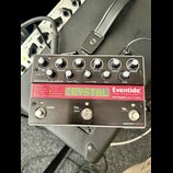 Kytarový efekt pedál značky Eventide s nápisy Harmonizer® a PITCHFACTOR. Zařízení má stříbrný kovový korpus, pět černých otočných oválů a dvě stoupac…