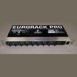 Stříbrný rackový mixér s černým horním krytem. Na krytu je velký bílý nápis EURORACK PRO a text PROFESSIONAL 16-INPUT LOW-NOISE LINE MIXER MODEL RX16…