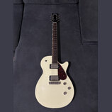 Bílá elektrická kytara s tvarem připomínajícím Les Paul a tmavým hmatníkem. Na hlavě je nápis KRAETEN. Nástroj má dva humbuckery, tmavě červený plech…