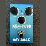 Modrý kytarový efekt s nápisy AQUA-PUSS, ANALOG DELAY MkIII a WAY HUGE. Na horní straně jsou tři černé otočné knoflíky s popisky DELAY, FEED BACK a B…