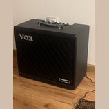 Černý kytarový kombozesilovač s texturovaným povrchem a černou přední síťovkou. V horní levé části je umístěno stříbrné logo VOX a v pravém dolním ro…