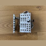 Bílé elektronické zařízení s nápisy opalha a hieroglyphic. Přední panel obsahuje několik posuvníků, otočný knoflík s nápisem frequency a různé konekt…