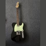Černá elektrická kytara typu Telecaster s bílým pickguardem a hnědým hmatníkem. Na hlavě kytary je viditelné logo "Ariari". Nástroj vykazuje známky b…