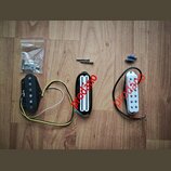 Tři kytarové snímače v různých provedeních: jeden černý s jedním řadou pólů, jeden černý humbucker s bílými cívkami a jeden bílý s jednou řadou pólů.…