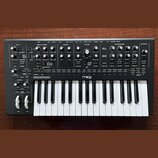 Černý analogový syntetizátor s bílými klávesami. Na předním panelu jsou rozloženy knofíky a přepínače v sekcích LFO 1, OSCILLATORS, MIXER, FILTER, EN…