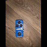 Modrý kytarový efekt pedál s nápisem FLASHBACK MINI a logem tc electronic. Na horní straně jsou tři ovládací knoflíky s popisky DELAY, F. BACK a LEVE…