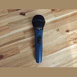 Modrý dynamický mikrofon s černou mřížkou. Na horní části těla je bílý nápis „audio-technica“ a pod ním „mb.“. Vprostřed těla se nachází přepínač s n…