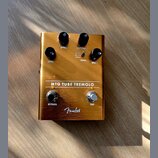 Zlatý kytarový efekt s nápisem MTG TUBE TREMOLO a logem Fender. Na horní straně jsou čtyři černé otočné ovnovátka s popisky LEVEL, SPEED, INTENSITY a…