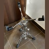 Chromovaný stojan na nástroje s čtyřramennou horní částí a černými gumovými oporami. Na středním sloupku je viditelný nápis "HAMMOND". Stojan stojí n…