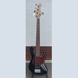 Černá elektrická basová kytara s červeně vzorovaným pickguardem a hnědým hmatníkem. Na hlavě nástroje je vidět logo Epiphone a nápis MarkExpress. Nás…