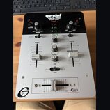 Stříbro-černý DJ mixér s nápisy gemini, PMX-350 a STEREO MIXER. Zařízení obsahuje dva kanály s posuvníky, centrální sekci s knoflíky a spodní crossfa…