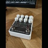 Bílý efekt pedál s osmi bílými oválnými ovladači. Na horním panelu je nápis PLATFORM a pod ním text stereo compressor/limiter. Ve spodní části je log…